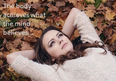 Woman lying in Autumn leaves thinking about healing.